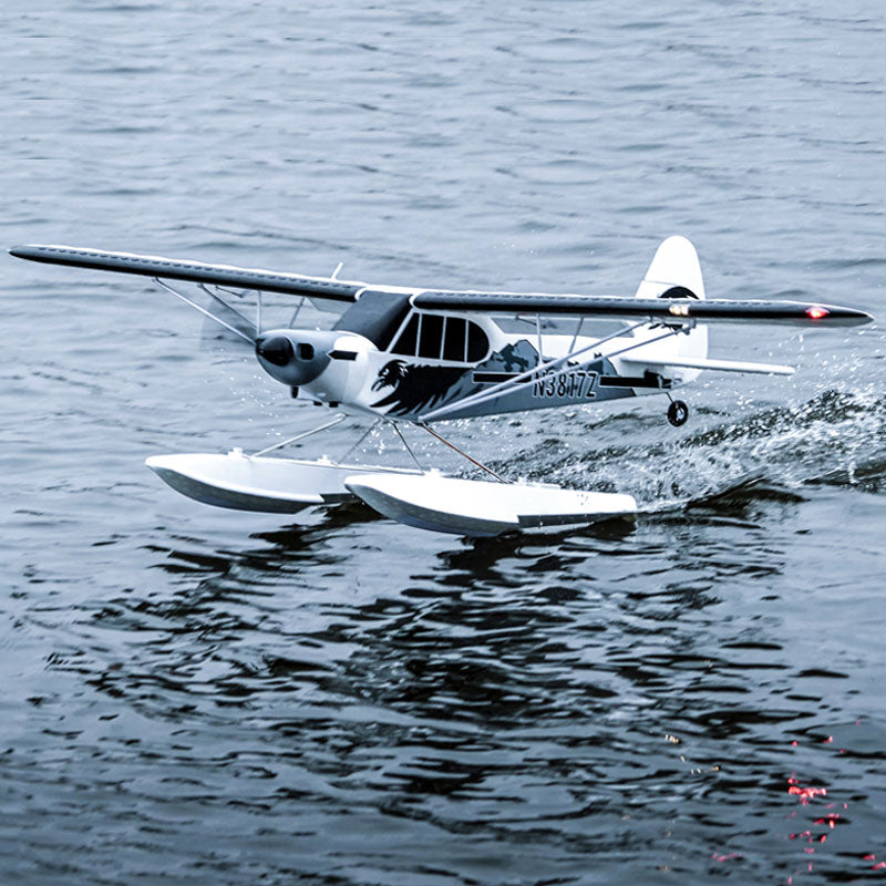 FMS PA-18 Super Cub airplane on water, demonstrating float capabilities.