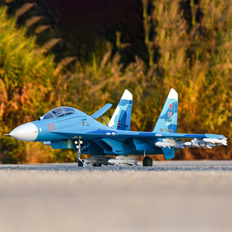 FMS SU-27 RC model in blue with white accents and missile details, ready for takeoff.
