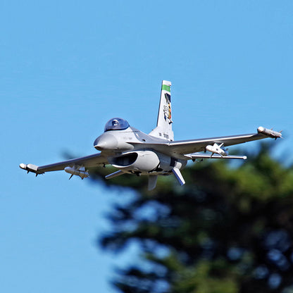 FMS 70mm F-16C Fighting Falcon jet flying against blue sky backdrop.