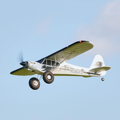 FMS 1300mm PA-18 Super Cub flying in the sky with clear blue background.