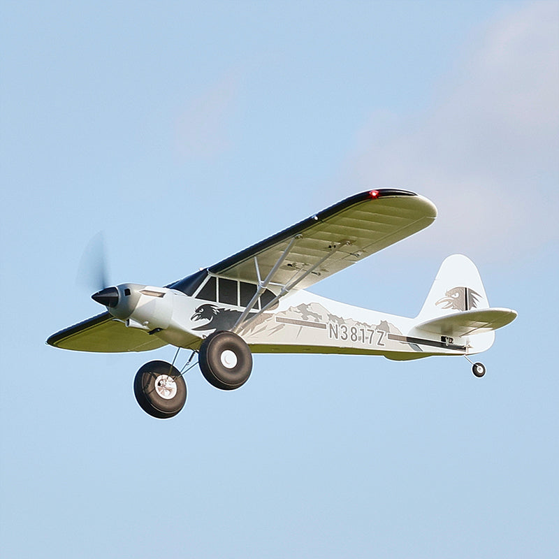 FMS 1300mm PA-18 Super Cub flying in the sky with clear blue background.