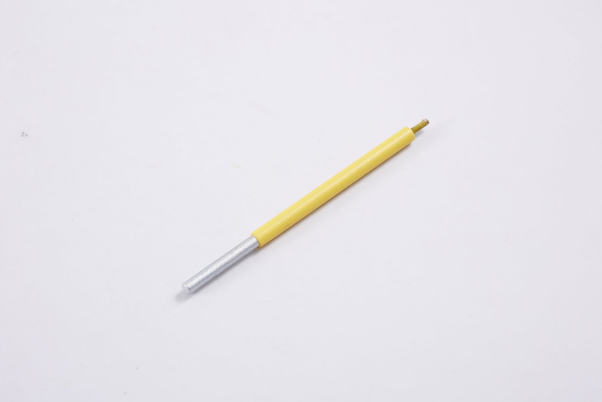 Yellow and silver pen on white background