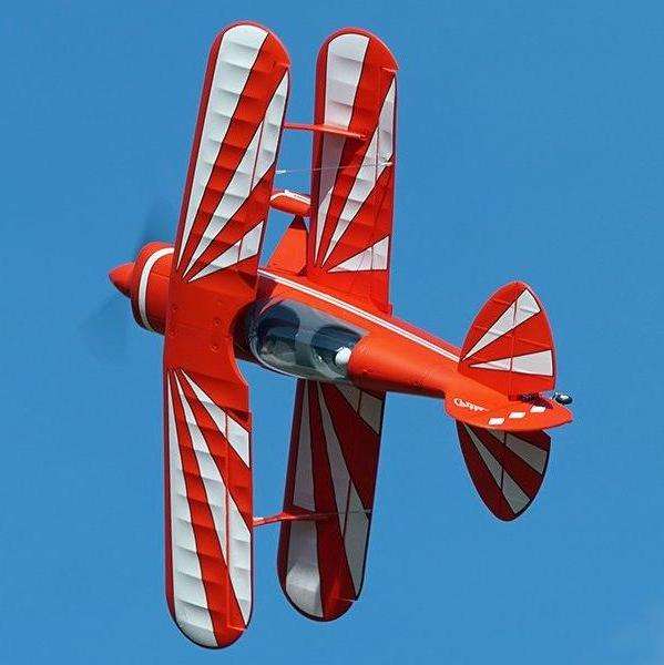 FMS Pitts V2 red biplane performing aerobatic maneuvers in blue sky