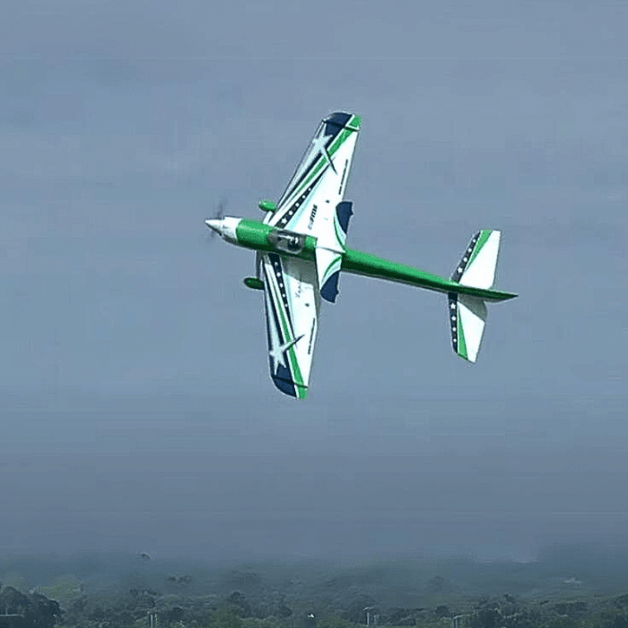 FMS F3A Explorer PNP doing aerial tricks with green and blue design.