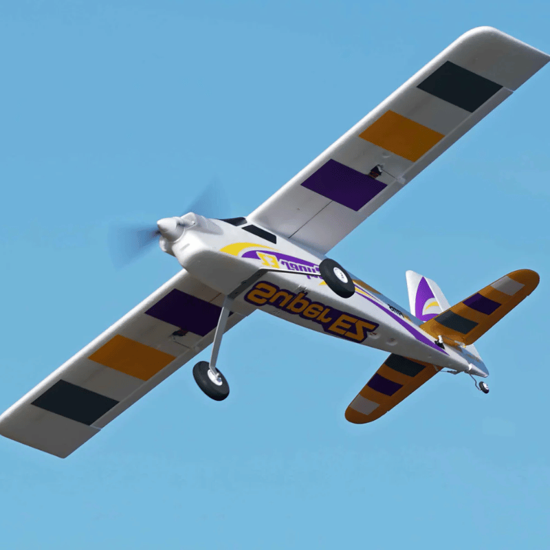 FMS Super EZ V4 RC airplane flying against a clear blue sky