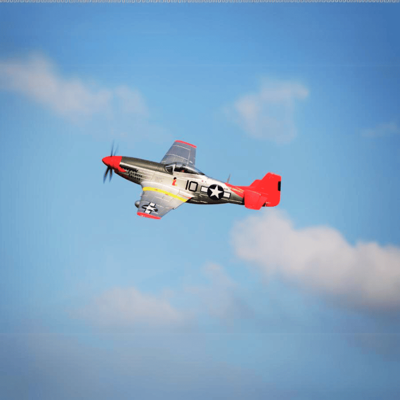 FMS 1400mm P-51D V8 RC plane flying in a clear sky with red tail and nose.