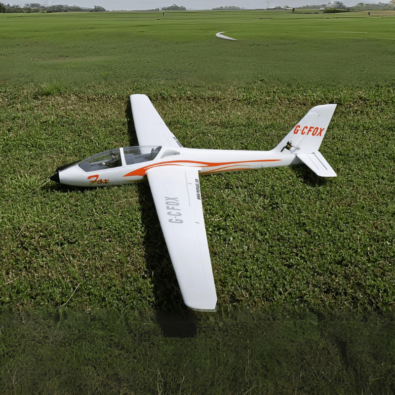 FMS 2300mm FOX V2 Glider resting on grass with orange and white design